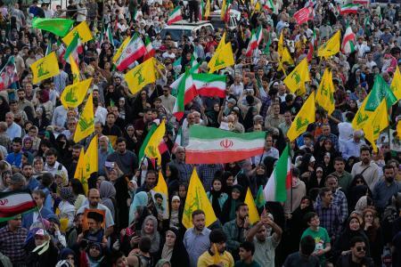 　イランの国旗とヒズボラの旗を掲げる人たち＝４日、テヘラン（ＡＰ＝共同）