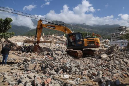 　２７日、ベネズエラの大地震後、倒壊した建物のがれきの中で被害者を捜索する救助隊（ゲッティ＝共同）