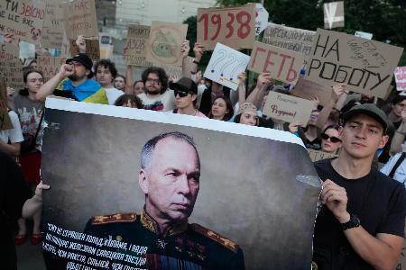 　抗議デモでウクライナのシルスキー軍総司令官の肖像を掲げる人＝１８日、キーウ（ＡＰ＝共同）