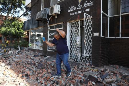 　１０日、コロンビア西部で発生した地震後、建物から離れる男性（ＡＰ＝共同）