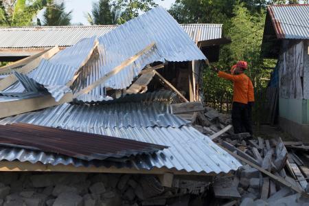 　インドネシア・東ヌサトゥンガラ州で、地震により倒壊した住宅を捜索する人＝１８日（ＡＰ＝共同）