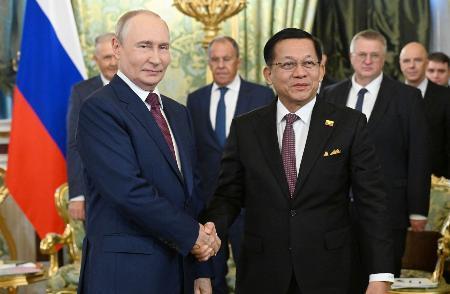　１８日、モスクワで握手するロシアのプーチン大統領（左）とミャンマー親軍政権の大統領ミンアウンフライン氏（ロシア大統領府提供・共同）