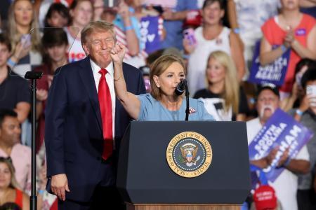 　２１日、米南部サウスカロライナ州マートルビーチでの集会で、ダーリン・グラム氏（手前）を見守るトランプ大統領（ＡＰ＝共同）