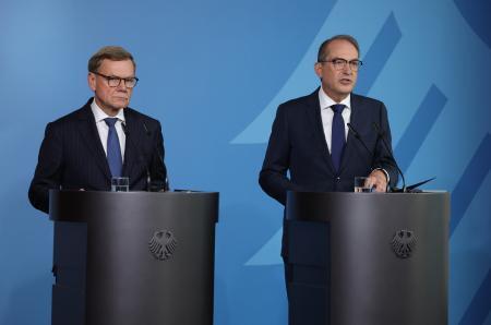 　１日、ベルリンで記者団の取材に応じるドイツのワーデフール外相（左）とドブリント内相（ゲッティ＝共同）
