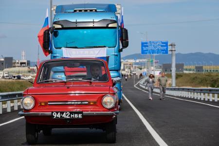 　７日、ロシアと北朝鮮を結ぶ自動車橋の開通式典で橋を通る車（タス＝共同）