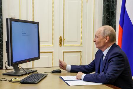　１８日、クレムリンの執務室からオンラインでロシア下院選の電子投票をするプーチン大統領（ロシア大統領府提供・タス＝共同）