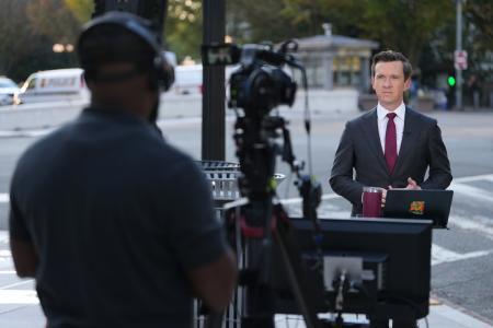 　２１日、米ホワイトハウス近くで報道するＭＳＮＯＷテレビの記者（ＡＰ＝共同）