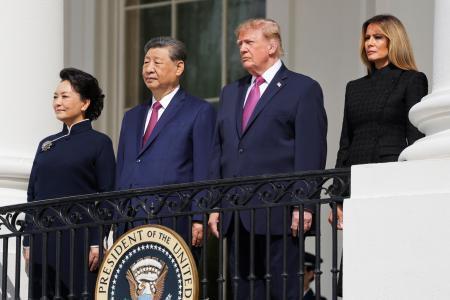 　ホワイトハウスのバルコニーに立つトランプ米大統領（中央右）と中国の習近平国家主席（同左）＝２４日、ワシントン（ロイター＝共同）