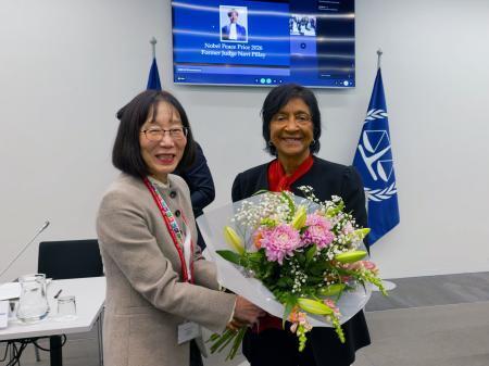 　国際刑事裁判所（ＩＣＣ）を訪問し、赤根智子所長（左）から花束を贈られるピレイ元国連人権高等弁務官＝１２日、オランダ西部ハーグ（ＩＣＣ提供・共同）