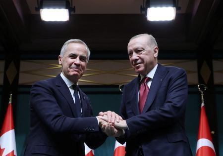 　２２日、トルコ・アンカラでの記者会見で握手するカナダのカーニー首相（左）とトルコのエルドアン大統領（ロイター＝共同）
