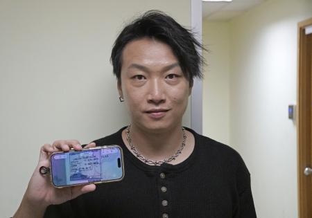 　日本への入国許可を示す書類の画像を見せる香港民主活動家の岑子杰氏＝６月、香港（共同）