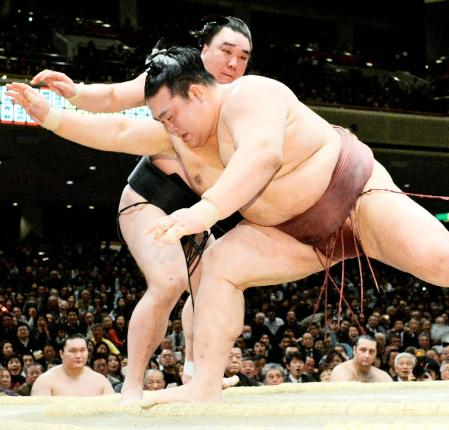 　日馬富士（奥）が送り出しで稀勢の里を下す＝両国国技館