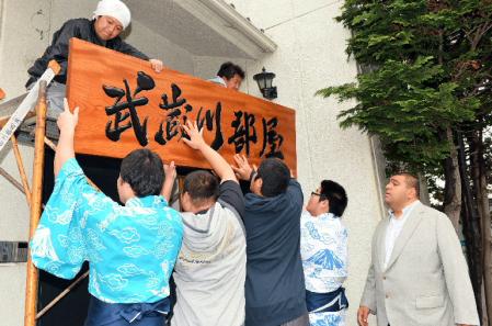 　弟子たちによって取り付けられる看板