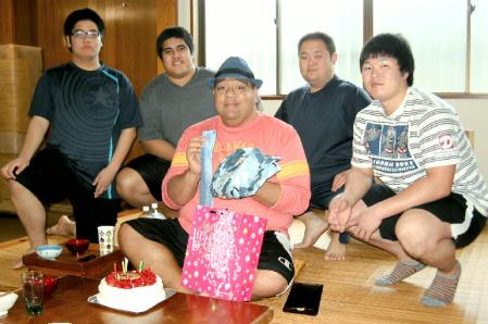 （後方左から）岡本、フィアマル、荒井、森宗に囲まれ、プレゼントを手に笑顔を見せる武蔵川親方