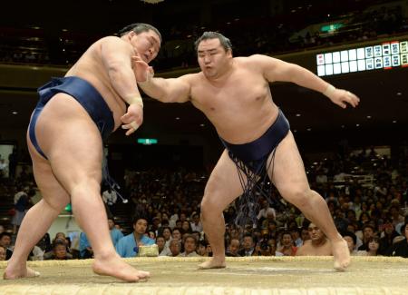 　力強い張り手で豪栄道（左）の体勢を崩しにかかる鶴竜（撮影・北野将市）