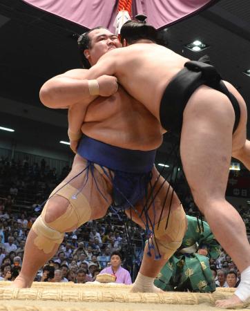 　日馬富士を寄り切りで破る琴奨菊（左）