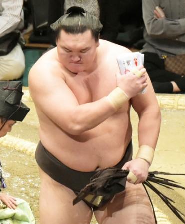 　宝富士を下し連勝をキープする白鵬は、懸賞金を手に引き揚げる