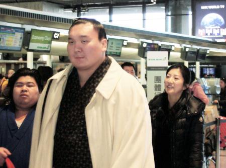 　紗代子夫人（右後方）とともにモンゴルに帰国するため空港に姿を見せた白鵬