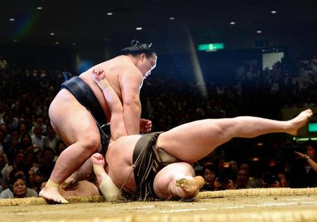 白鵬をつきおとしで破った稀勢の里（左）