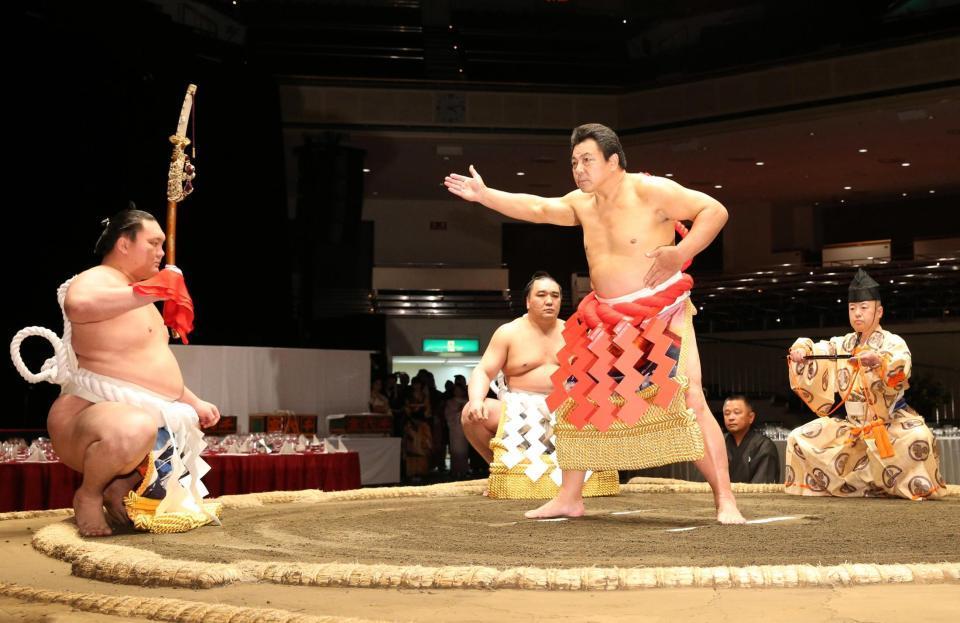 　還暦土俵入りを披露する九重親方。太刀持ちは横綱・白鵬、露払いは横綱・日馬富士