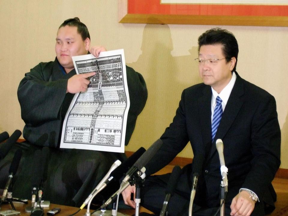 新大関になった照ノ富士は新しい番付表を手に気合を入れる。右は師匠の伊勢ケ浜親方。（名古屋市瑞穂区の伊勢ケ浜部屋宿舎）