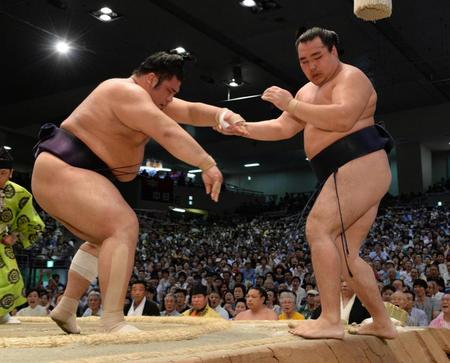 鶴竜（右）を押し出しで破る栃煌山