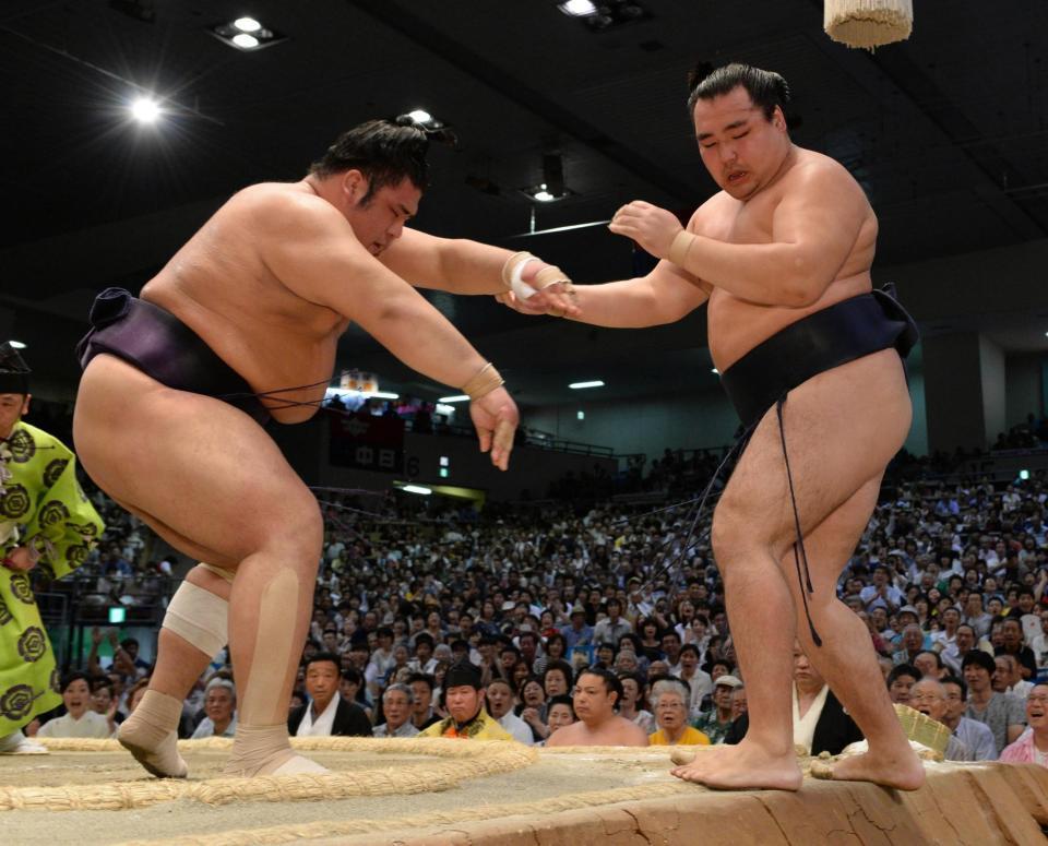 鶴竜（右）を押し出しで破る栃煌山