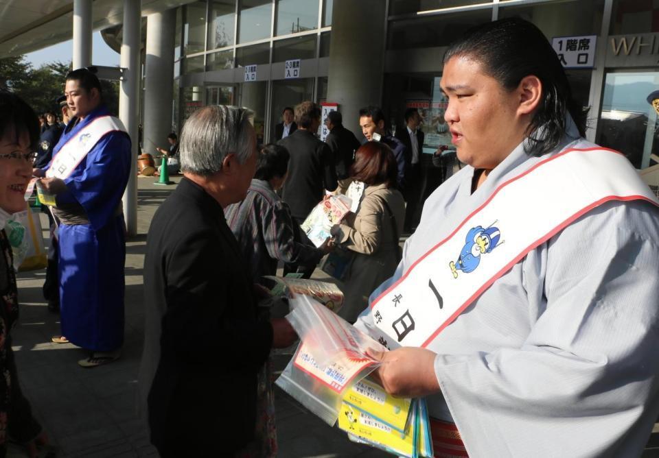 　一日警察署長としてチラシを配る御嶽海（右）。左は遠藤