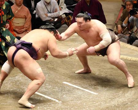 　立ち合いで右手を出して栃煌山（左）をけん制する白鵬