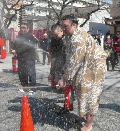 　火災訓練で水をまく稀勢の里＝大阪市内の田子ノ浦部屋