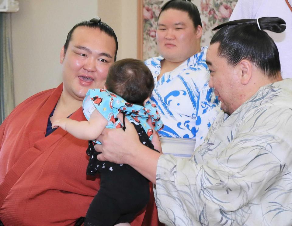 　ファンとの記念撮影のイベントで、泣く子をあやす稀勢の里（左）と日馬富士（右）