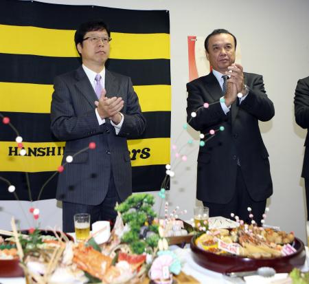 　乾杯後、拍手する南球団社長（左）と中村ＧＭ