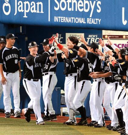 ８回阪神無死、阪神　マット・マートンは左越えに決勝ソロホーマーを放ち、ナインに迎えられる＝横浜スタジアム（撮影・金田祐二）