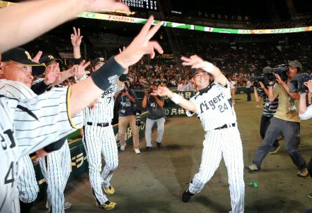 ヒーローインタビューが終わるまでベンチで待っていた阪神・西岡　剛らナインとグラティーを決める阪神・桧山進次郎＝甲子園（撮影・飯室逸平）