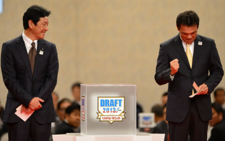 横浜商科大・岩貞の交渉権を獲得し、控えめにガッツポーズする阪神・和田豊監督。左は日本ハム・栗山監督＝東京・新高輪プリンスホテル