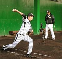 ビデオで録画しながらブルペンで投げ込む藤浪。右は中西コーチ。