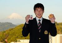 富士山に見守られ、清水次郎長の勝札を手に笑顔を見せる国士舘大・岩崎（撮影・園田高夫）