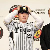 　背番号２２のユニホームに袖を通し帽子をかぶる呉昇桓＝ソウル市内のホテル（撮影・棚橋慶太）