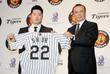 呉昇桓（左）に背番号２２のユニホームを手渡す中村ＧＭ＝ソウル市内のホテル（撮影・棚橋慶太）