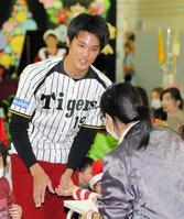 　クリスマスイベントで子供と握手する藤浪（撮影・田中太一）