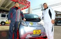 三菱から無償貸与されたタイガースロゴ入りの電気自動車を前に笑顔の掛布ＤＣ（右）と平田２軍監督＝高知三菱自動車販売安芸店（撮影・保田叔久）