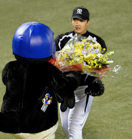 　通算１０００奪三振を達成しつば九郎から花束を受け取る福原