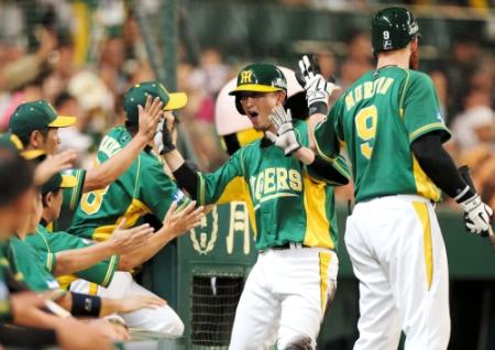 ４回、阪神・鳥谷の勝ち越し適時打で生還しベンチ前で大騒ぎの今成（中央）＝甲子園（撮影・保田叔久）