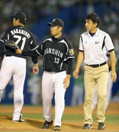 　５回、権田トレーナー（右）に付き添われ途中降板する榎田（撮影・田中太一）