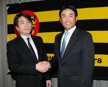 　高野本部長（左）と握手をする香田２軍投手コーチ