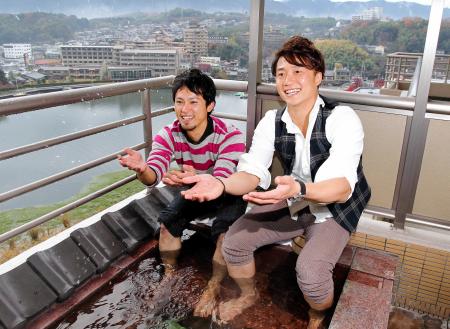 　琵琶湖の雄大な景色を背に足湯を楽しむ上本（左）と新井良