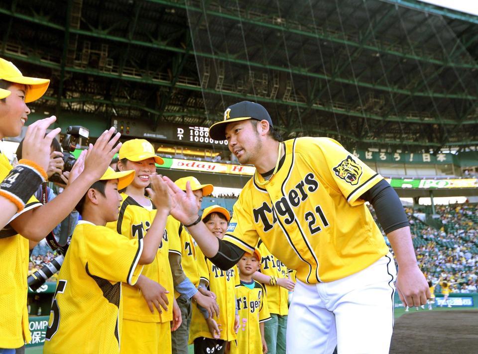 　投打のヒーローとなり、子供たちと勝利のタッチを交わす岩田（撮影・田中太一）