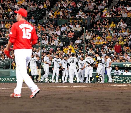 　５回、黒田（左）をなかなか攻略できず、ベンチ前で円陣を組む阪神ナイン