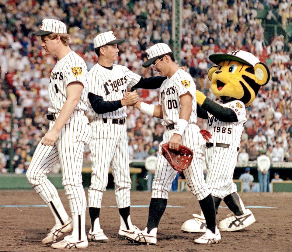 最終戦を勝って２位を確保し、亀山（右）、オマリー（左）らをねぎらう中村勝広監督＝１９９２年１０月１１日、甲子園