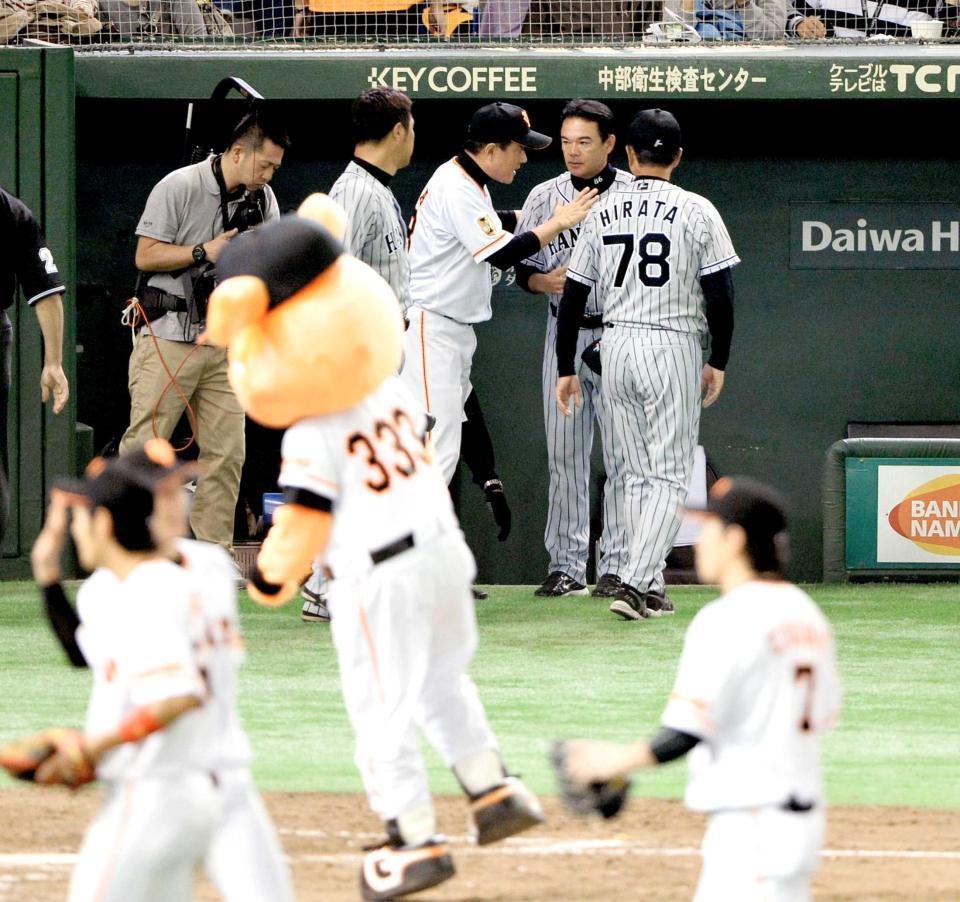 　試合後に歩み寄ってきた原監督にねぎらわれる和田監督（撮影・村中拓久）